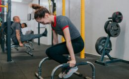 Focused group of young adults exercising intensely with gym equipment indoors.