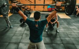 A group of men engaged in a vigorous weightlifting session at a gym.